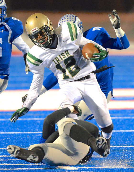 Jeff Lange | The Vindicator  Akron St. Vincent-St. Mary's Markus Hurd (12) is tackled by a Hubbard defender at the knees as he is pursued by Tyler Taafe (10) during third quarter action of their 26-23 victory over the Hubbard Eagles, Friday night in Ravenna.