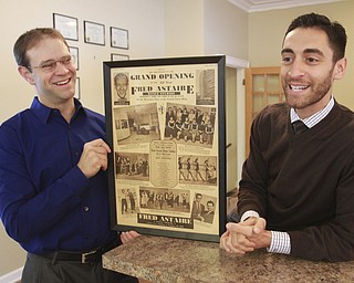 William D Leiws the Vindicator FredAstaire Dance Studio , Boardman owners Dustin Jones, left, and Travis Manero look over a framed Vindicator page from the 1950's detailing the grand opening of a studio in downtown Youngstown. The business is celebrating its 60th anniv.