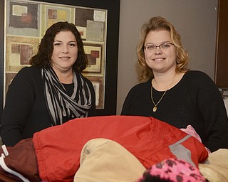 Katie Rickman | The Vindicator.Lisa Weimer (on right) stands with her friend Liz Klase near a pile of donated coats at Weimer's Poland home (both are from Poland) on Wednesday, Nov. 19, 2014.  Klase is Weimer's go-to for cookies or cakes for any benefit she does, Liz owns Liz's Cakes.