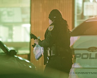        ROBERT K. YOSAY  | THE VINDICATOR.. A police spokesman said a store owner and the man who tried to rob the store exchanged gunfire and both were hit late this afternoon. according to Brad Blackburn - the shooting is under investigation. and Conditions were not known...a policeman carries evidence at the scene
