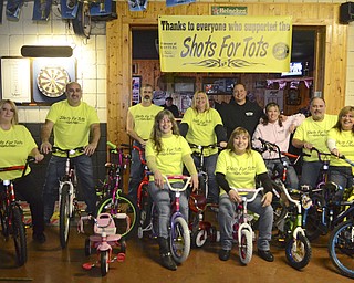 Katie Rickman | The Vindicator. Front row L-R.Cat Channell, Patty Wright, Monica Grachanin, and Joan Dalessandro.Back Row L-R .John Grachanin, Virgin Minniti II, Debbie Minniti, Dave Cordy, Michelle Scott, and Dave Wright..pose for a photo on bikes donated for Shots for Tots at Master's Bar and Grill in Liberty Twp. on Wednesday, Nov. 19, 2014.