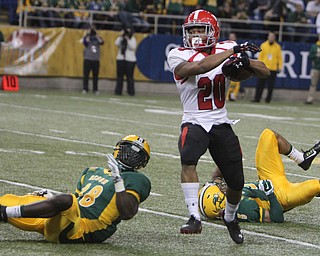 Youngstown State's Jody Webb (20) regains his balance while getting through a tackle by North Dakota State's Carlton Littlejohn (38) during the first quarter of Saturday afternoons matchup at the Fargodome in North Dakota.  Dustin Livesay  |  The Vindicator  11/22/14  Fargo, North Dakota.