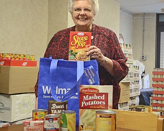 Katie Rickman | The Vindicator.Sister Jean Orsuto, Director of the Emmanuel Care Center in Girard poses for a photo with food that will be packed for families with Thanksgiving foods on Friday, Nov. 21, 2014.