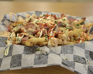 Katie Rickman | The Vindicator.A traditional Peruvian street vendor food is an unusual find in the United States but the plate can be found at Calle Doce in Campbell, featured here is "Salchipapas" which is french fires topped with hot dogs, and sauces.