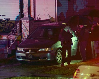 Katie Rickman | The Vindicator .Officials survey the scene of a suspected homicide on the 700 block of Lexington Avenue in Youngstown Sunday night.