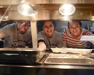 Katie Rickman | The Vindicator.Mohamed Mishmish of Boardman, Lina Adi of Youngstown, and Sofija Javor of Youngstown serve free turkey dinners to the community at Downtown Circle Deli in Youngstown on Sunday, Nov. 23, 2014.