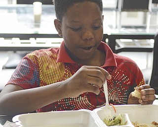 Katie Rickman | The Vindicator.Sage Hallman 10, of Youngstown eats a turkey dinner at Downtown Circle Deli where volunteers served over 200 free dinners on Sunday, Nov. 23, 2014.