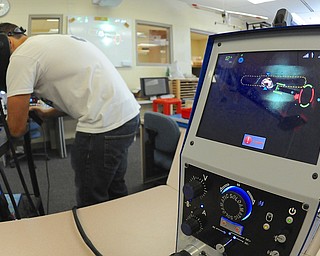 Jeff Lange | The Vindicator  The Soldamatic (at right) grades Lowellville senior Michael Kacer as he practices arc welding during Friday morning classes at Lowellville.