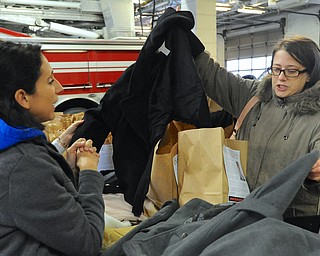 Jeff Lange | The Vindicator  Sheila Carr of Warren (right) gets assistance from volunteer Jackie Braccio (left) in deciding which coat she should take from the D.A.L.E. coat drive held at the Warren Central Fire Station, Saturday afternoon.