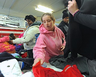 Jeff Lange | The Vindicator  Brittany Bender of Warren (center) and Jamey May (back left) pick out coats during the D.A.L.E. Foundation Thanksgiving Giveaway held at the Warren Central Fire Station, Saturday afternoon.
