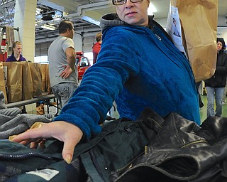 Jeff Lange | The Vindicator  Lisa Cruz of Warren reaches for a jacket off the table during the D.A.L.E. Foundation Thanksgiving Giveaway held at the Warren Central Fire Station, Saturday afternoon.