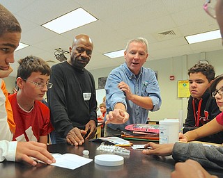 Jeff Lange | The Vindicator  Clifton Moton (far left), Jeremy Clemente (left), Gerald King of GM (left center), Donald Roush of Earth Force (center), Alex Phelps (right center) and Mariah Lopez (far right) work together to determine the PH of water found in Yellow Creek, Friday afternoon at Struthers Middle School.