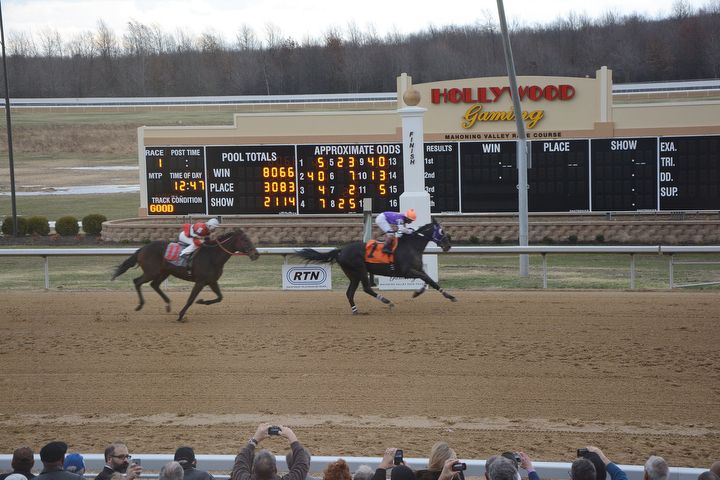        ROBERT K. YOSAY  | THE VINDICATOR..Windy but warm temperatures had the Hollywood Gaming Racino parking lot filled as people came out to watch the inagural run of thoroghbred racing in the Mahoning Valley...and the winner of the Inagural  BABY TIME  is followed by    "Take a Walk"