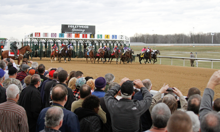        ROBERT K. YOSAY  | THE VINDICATOR..Windy but warm temperatures had the Hollywood Gaming Racino parking lot filled as people came out to watch the inaugural run of thoroghbred racing in the Mahoning Valley...and there off as people gather at the rail 5-6 deep