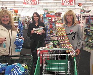 Special to The Vindicator — Members of Youngstown Lions Club, from left, Nancy Cuffle, Patti Atwood and Patti Nichols, shop for scarves, hats, gloves, candy and other gifts for visually impaired and special needs children who will attend the club’s 93rd annual Christmas party Dec. 2 at the Saxon Club in Youngstown. About 120 children from Mahoning Valley schools and adults from Goodwill Industries will celebrate with club members and Santa and Mrs. Claus. Lions will wrap the gifts when they meet at 6:30 p.m. Dec. 1 at the Saxon Club. Funding for the holiday project is from sponsors of Youngstown Lions’ annual Turtle Derby, its only fundraiser.
