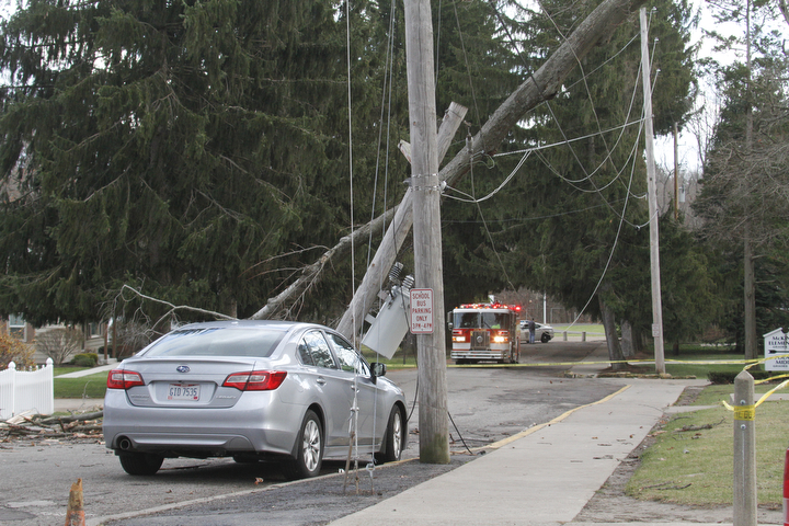        ROBERT K. YOSAY  | THE VINDICATOR..Strong winds and  a broken tree branch fell on a wire that snapped a telephone pole and then landed on the hood knocking out power to  an area around the Poland Middle School....