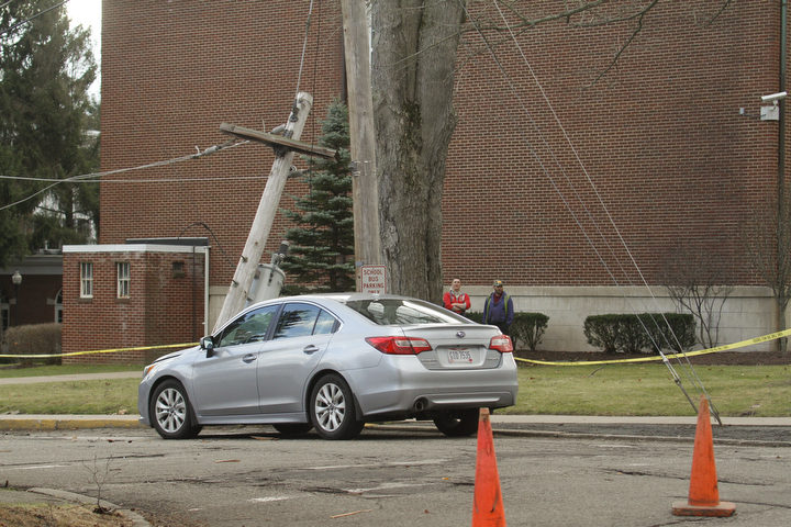        ROBERT K. YOSAY  | THE VINDICATOR..Strong winds and  a broken tree branch fell on a wire that snapped a telephone pole and then landed on the hood knocking out power to  an area around the Poland Middle School....