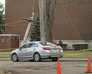        ROBERT K. YOSAY  | THE VINDICATOR..Strong winds and  a broken tree branch fell on a wire that snapped a telephone pole and then landed on the hood knocking out power to  an area around the Poland Middle School....