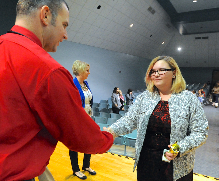 Jeff Lange | The Vindicator  8th grader at Struthers Kylie Thomas shakes the hand of Principle Pete Pirone (left) after being awarded first place for her group's restaurant after Struthers Middle School's "Wildcat Cage" a spinoff of the TV show Shark Tank, Monday afternoon.