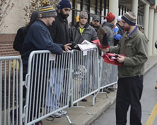 Katie Rickman | The Vindicator.Alvin Carroll of Austintown hands out tickets to customers as they wait in line for Best Buy's Thanksgiving sale to begin at 5 p.m.  on Thursday, Nov. 27, 2014. Many customers waited for hours in the in the cold temperatures to be among the first in the store.