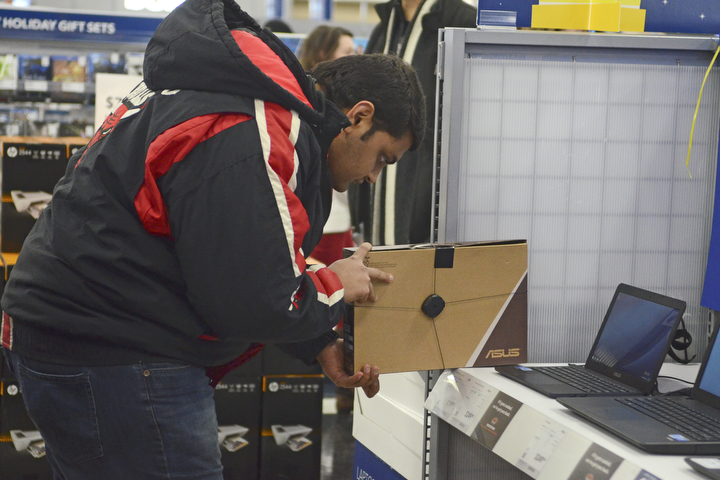 Katie Rickman | The Vindicator.Rinkeh Prajapati of Eerie, Pennsylvania looks at a lap top at Best Buy in Boardman during the Thanksgiving Day sale on Thursday, Nov. 17, 2014.