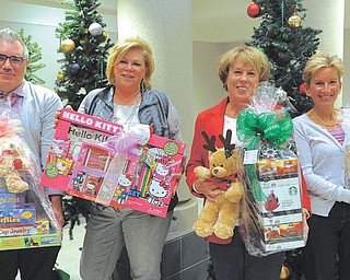 Akron Children’s Hospital Mahoning Valley will benefit from two upcoming holiday fundraisers: Breakfast with Santa on Saturday and Holiday Hopes and Wishes luncheon on Dec. 12. From left to right, Dennis Dively, Dillard’s visual merchandiser; Debbie Shattuck of DMW Insurance; Donna Hayat; and Kathy Dwinnells of Hopes and Wishes stand in front of the Christmas display at the hospital. JEFF LANGE | THE VINDICATOR