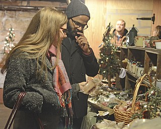 Katie Rickman | The Vindicator.Kami Conrad of Austintown and Ravi Yenugu of West Lake, Ohio, look at homemade soaps at Lanternman's Mill at Mill Creek Park's Olde Fashioned Christmas on Saturday, Nov. 29, 2014.