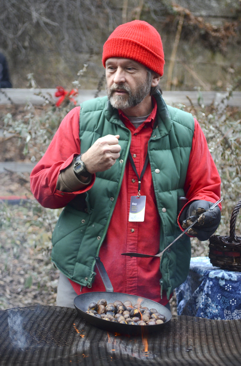 Katie Rickman | The Vindicator.RAy Novotny an Outdoor Educator Manager with Mill Creek MetroParks roasts chestnuts over a fire during the Olde Fashioned Christmas at Lanterman's Mill at Mill Creek Park on Saturday, Nov. 29, 2014.