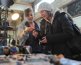 Jeff Lange | The Vindicator  Stacey D'Angelo (left) helps her friend Reba Babyak of Youngstown decide which pendant to purchase from Saturday's open studio at the Ward Bakery.