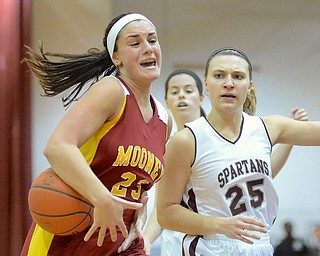 Jeff Lange | The Vindicator  Jaclyn Yankle (23) of Mooney loses control of the ball as she makes her way to the basket past Boardman's Amber McMillan (25) in the first period of their matchup, Saturday evening in Boardman.