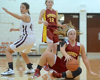 Jeff Lange | The Vindicator  Mooney's Jami Difabio maintains possession of the ball as she falls to floor while Mooney's Taylor Martin (12) and Boardman's Anna Saxton (41) look on from behind in the third period of Saturday's matchup in Boardman.