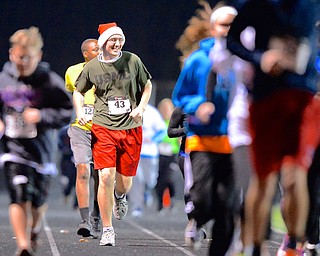 Jeff Lange | The Vindicator  Runner Matt Mosier (43) smiles as he trails behind the pack while running in the over 6 minute mile race, Sunday evening at Austintown High School.