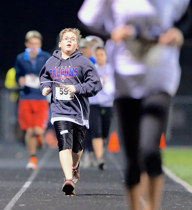 Jeff Lange | The Vindicator  Austintown's Graham Bosley (59) looks on at the runner ahead of him as he nears the finish line of the mile race, Sunday evening at Austintown High School during the 1st ALS Polar Run.