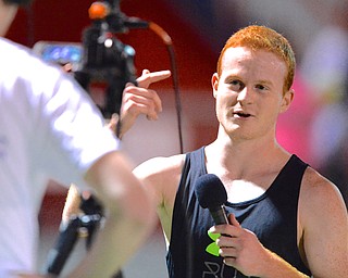 Jeff Lange | The Vindicator  Josh Potkanowicz (right) speaks to the camera during a post-race interview. Potkanowicz captured first place in the under 6 minute mile race, Sunday during the Polar Run at Austintown Fitch High School.