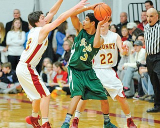 Ursuline guard Mike Hughes looks to pass to a teammate while being pressured by Mooney defenders Mark Handel (22) and Joe Cunningham (23) during a game last season. The Wright State recruit will lead the Irish this winter.