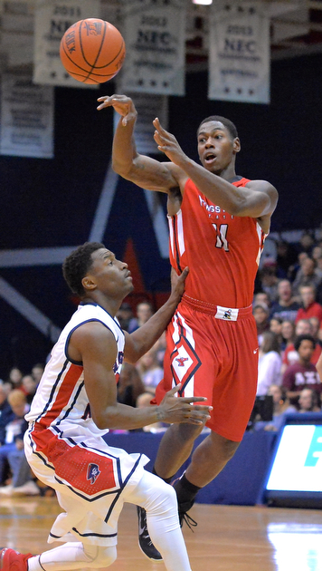 Jeff Lange | The Vindicator  Youngstown's DJ Cole (11) hops to make a pass over Colonials' Kavon Stewart in the second half of Tuesday's matchup in Moon, PA.