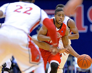 Jeff Lange | The Vindicator  Penguins' Marcus Keene (right) dribbles the ball down court through a host of Colonials defenders in the second half of their matchup, Tuesday night in Moon, PA.