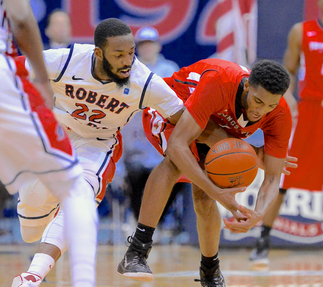 Jeff Lange | The Vindicator  Penguins' Jalon Plummer (right) has the ball knocked away by Colonials' Lucky Jones (22) in the final moments of their matchup, Tuesday night in Moon, PA.
