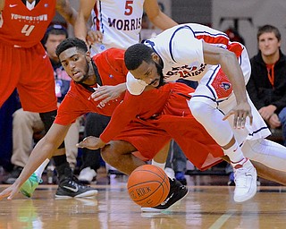 Jeff Lange | The Vindicator  Lionel Gomis of Youngstown (back) dives to the floor with Robert Morris' Lucky Jones (right) for possession of the ball in the first half of Tuesday night's game in Moon, PA. Youngstown downed the Colonials 89-81.