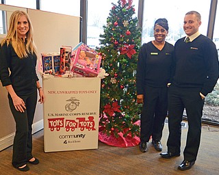 Employees at the Huntington Bank office, 3499 Belmont Ave., Liberty, stand beside the overflowing collection box for the Marine Corps Reserve’s Toys for Tots campaign. From left are Lindsay Lemke, personal banker; Denise Smith, teller; and Steven Sicilian, assistant manager.