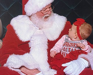 Arilynn Yankey, 7 months, talking with Santa. Her shirt reads "Santa's Little Helper."