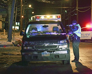 Katie Rickman | The Vindicator.A police officer looks into the cab of a truck that his a pedestrian on Logan Avenue and Thornton Avenue in Youngstown on Friday, Nov. 28, 2014. Officials have no released information on the accident.