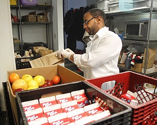        ROBERT K. YOSAY  | THE VINDICATOR..Helping pack  food backs for dinner ..  is Brent Boyd.....The Webster family again spent the Friday after Thanksgivng  at the Rescue Mission preparing food as their Patriarch and Matriarch of our family, Donald and Louise Webster (both deceased.) They were long time residents of Youngstown ..-30-