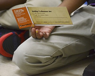 Katie Rickman | The Vindicator.A student holds on to a pledge that former NBA star Michael Morrison handed out during a special assembly at Stambaugh Charter Academy on Tuesday, Dec. 2, 2014.