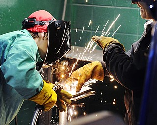 Jeff Lange | The Vindicator  Jenn Foit of Youngstown (left) gets assistance in mig welding from her instructor Sonny Ziobert during Monday's class at MCCTC.