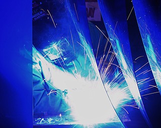 Jeff Lange | The Vindicator  Esther Thomas of Struthers can be seen welding through the protective curtain of her booth during class, Monday afternoon at MCCTC in Canfield.