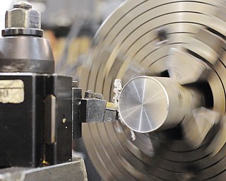 Jeff Lange | The Vindicator  The automatic turning lathe turns down the diameter of a piece of aluminum rod.