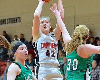 Jeff Lange | The Vindicator  Canfield's Erin Risner (42) looks to shoot a 2 over West Branch's Paige Walsh (left) and Catie Hahn (right) during first period action of Wednesday night's matchup in Canfield.