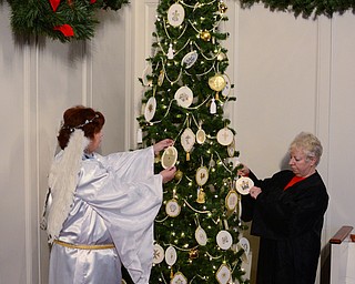 Church secretary member Aleta Hostetler, left, and Director of Religious Education Susan Stoddart, right, hang ornaments on the Chrismon tree at Central Christian Church in Warren.