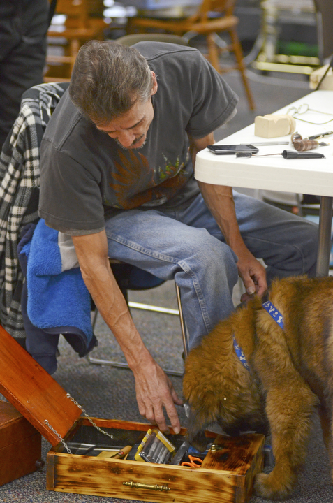 Katie Rickman | The Vindicator.Darrell Hassler of Austintown attempts to keep Mr. Fluffy out of his wood carving tool box at the Austintown Senior Center on Thursday, Dec. 4, 2014.Mr. Fluffy is an 12-week-old Leonberger dog that spends his days visiting seniors at the center.